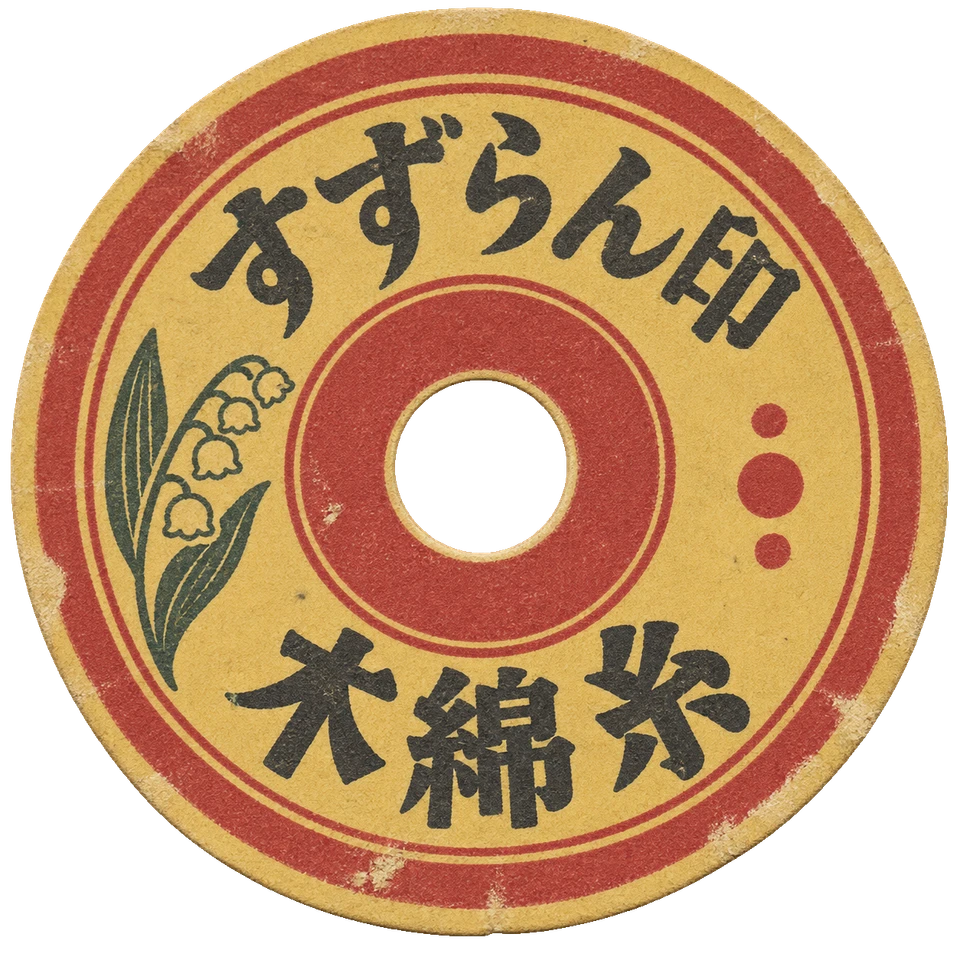 小さなすずらんの図案を添えた、中央に穴のある丸い糸巻ラベル。