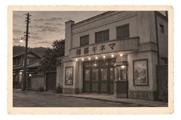 手描き風の上映ポスターと小さな窓口が並ぶ、夕方の架空の映画館。